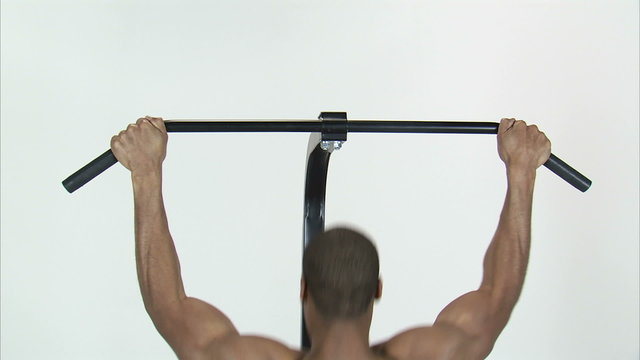 Royalty Free Stock Footage of Back of a man doing pull-ups on a white background.