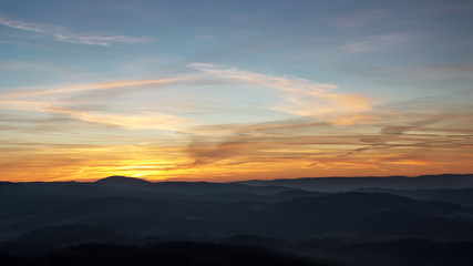 Sunset over the hills in the fog.
