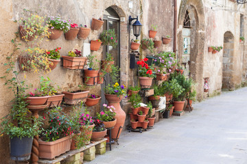 Fototapeta na wymiar Ceramic Flower Pots Hang on Old Italian Wall