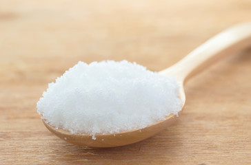 Fototapeta na wymiar white sugar in wood spoon on wood table