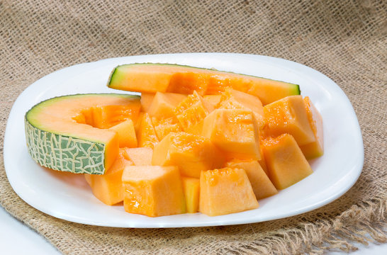 Melons, cantaloupe slices on fabric background