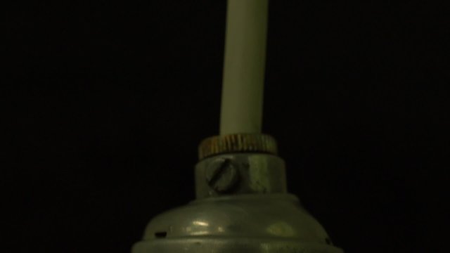 close up of glowing element in the incandescent light bulb, showing hot wire glow by electric current flowing in the tungsten filament