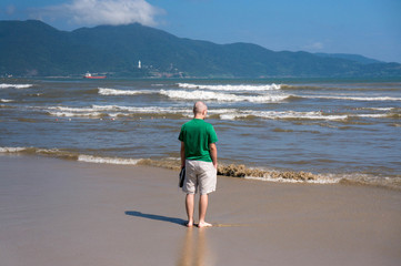 Young caucasian man stands on the beach of Da Nang, Vietnam.