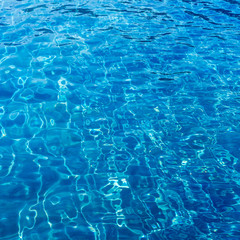 Background of rippled pattern of clean water in blue swimming po