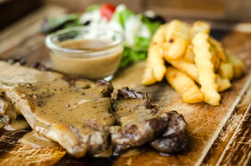 Striploin Steak with salt and pepper on meat cutting board