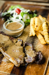 Striploin Steak with salt and pepper on meat cutting board