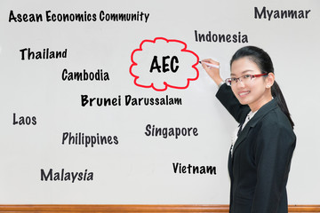Asian Woman teacher writing AEC and member wording in whiteboard