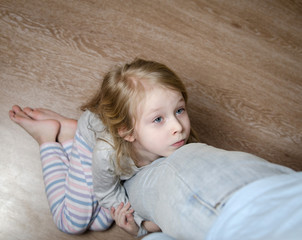 Young girl hugging her father's leg