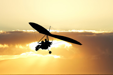 Hang gliding in the sky at sunset