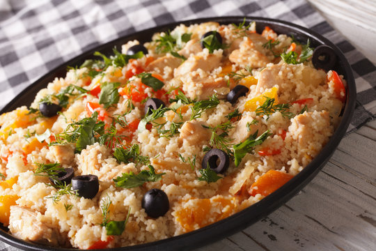 Couscous salad with chicken, olives and vegetables close-up. Horizontal
