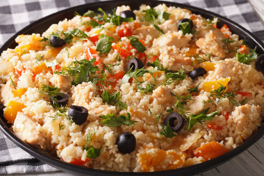 couscous with chicken, olives and vegetables close-up. horizontal
