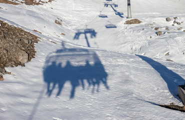 Silhoette of skiers on chairlift