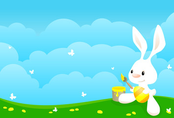 Cute easter bunny painting an egg.
