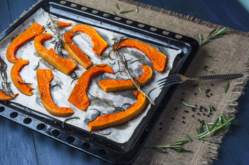 Slices of baked pumpkin on baking tray