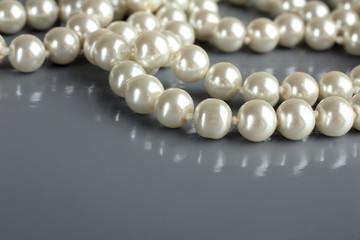 pearl beads and pearls with reflection on gray background