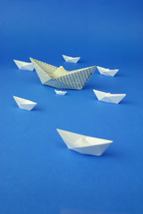 Paper ships origami on blue background.