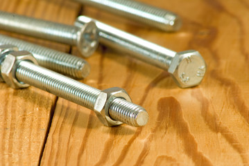 image of bolts on a wooden board close-up