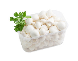 Button mushrooms in a plastic tray on a light background