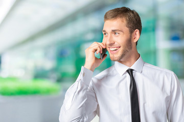 Young handsome businessman talking on mobile phone