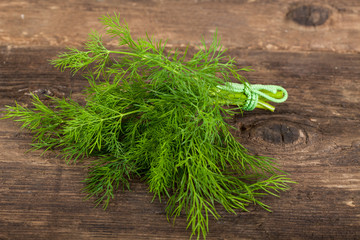 Fototapeta premium Bunch of fresh organic dill on a rustic wooden background