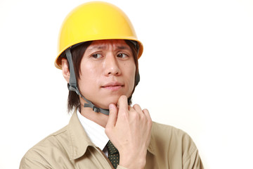 young Japanese construction worker worries about something
