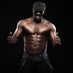 Fototapeta na wymiar Portrait of an athletic african american man topless. Only in suspenders and cap