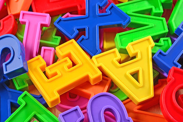 Heap of plastic colored alphabet letters close up