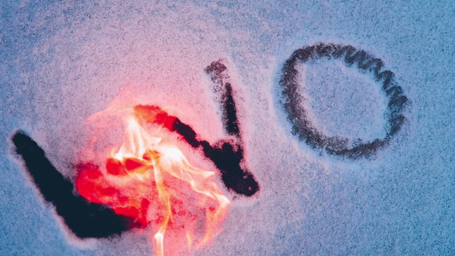Aka of the producer of L YO written on snow is set fire. Reverse video close up.