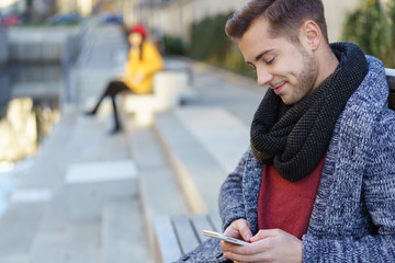 junger mann tippt eine nachricht auf seinem smartphone