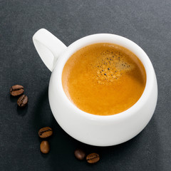 cup of espresso on a black background, top view