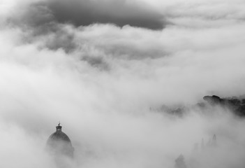 Church of Cortona immersed in fog in Tuscany - Italy