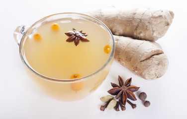 Obraz na płótnie Canvas Spiced tea with sea buckthorn and ginger and spices on a white