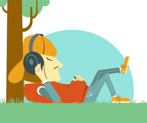 Young boy listening to music on nature green grass