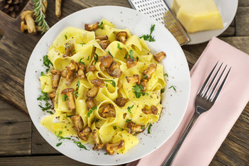 Frische Pfifferlinge an Bandnudeln auf weißem Teller 