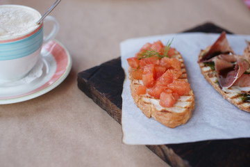 Разные брускетты на деревянной доске на столе