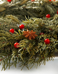 Christmas card. New Year background. Christmas wreath with cranberries, rowan and cloves. New Year tree.