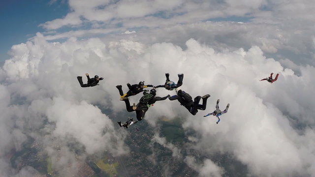 Sky diving group through the clouds.