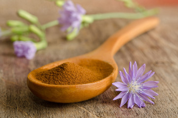 Blue chicory flower and full wooden spoon of powder  instant chi © Soyka