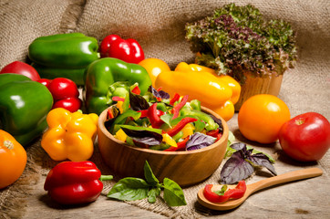 salad from bell pepper and basil in a wooden bowl and tomato on