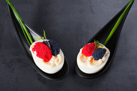 Appetizer on fingerspoon egg with caviar