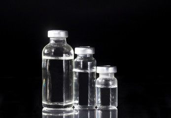 Glass Medicine Vials and Syringe on black background