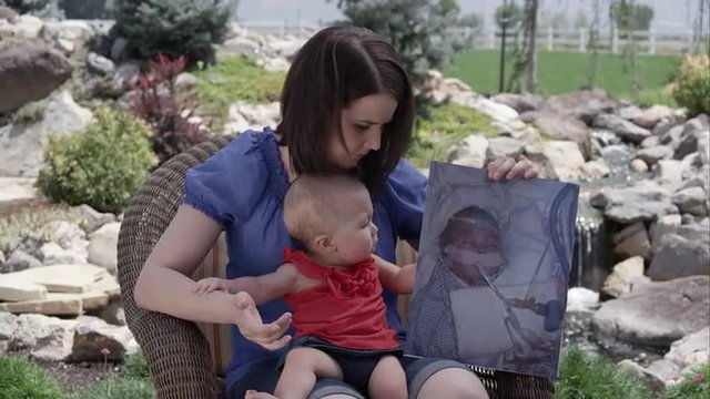 Slow motion of woman holding baby girl and picture of her in the hospital.