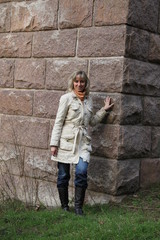 Frau steht neben einer Mauer