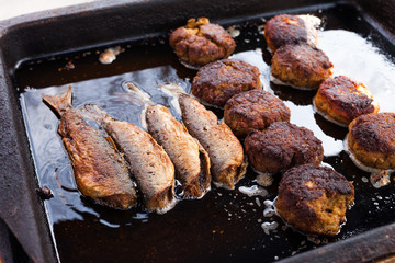 Cod (Dorsch) filets and frikadeller (frikadelle) cooking in oil