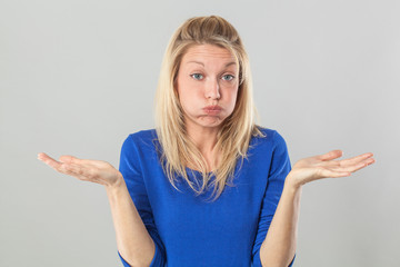 fatigue or boredom concept - frustrated young blond woman puffing her cheeks out for resignation and disillusion with hand gesture,studio shot - obrazy, fototapety, plakaty