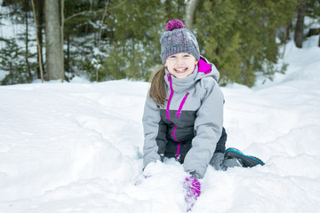 Fototapeta na wymiar Little girl in winter season with hat in snow.
