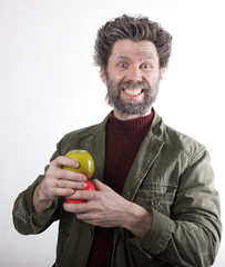 Mr. IceMan, smiling man with a beard, beard covered with hoarfrost, man holding apples, he stares at them. fashion man in knitted sweater and jacket. 