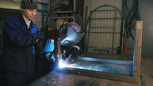 Two men are working  with welding apparatus. Close-up.