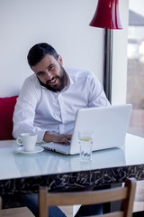 Handsome business man sitting in coffee shop and working on his laptop,shallow depth of field