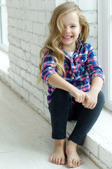 Happy little girl near wall 